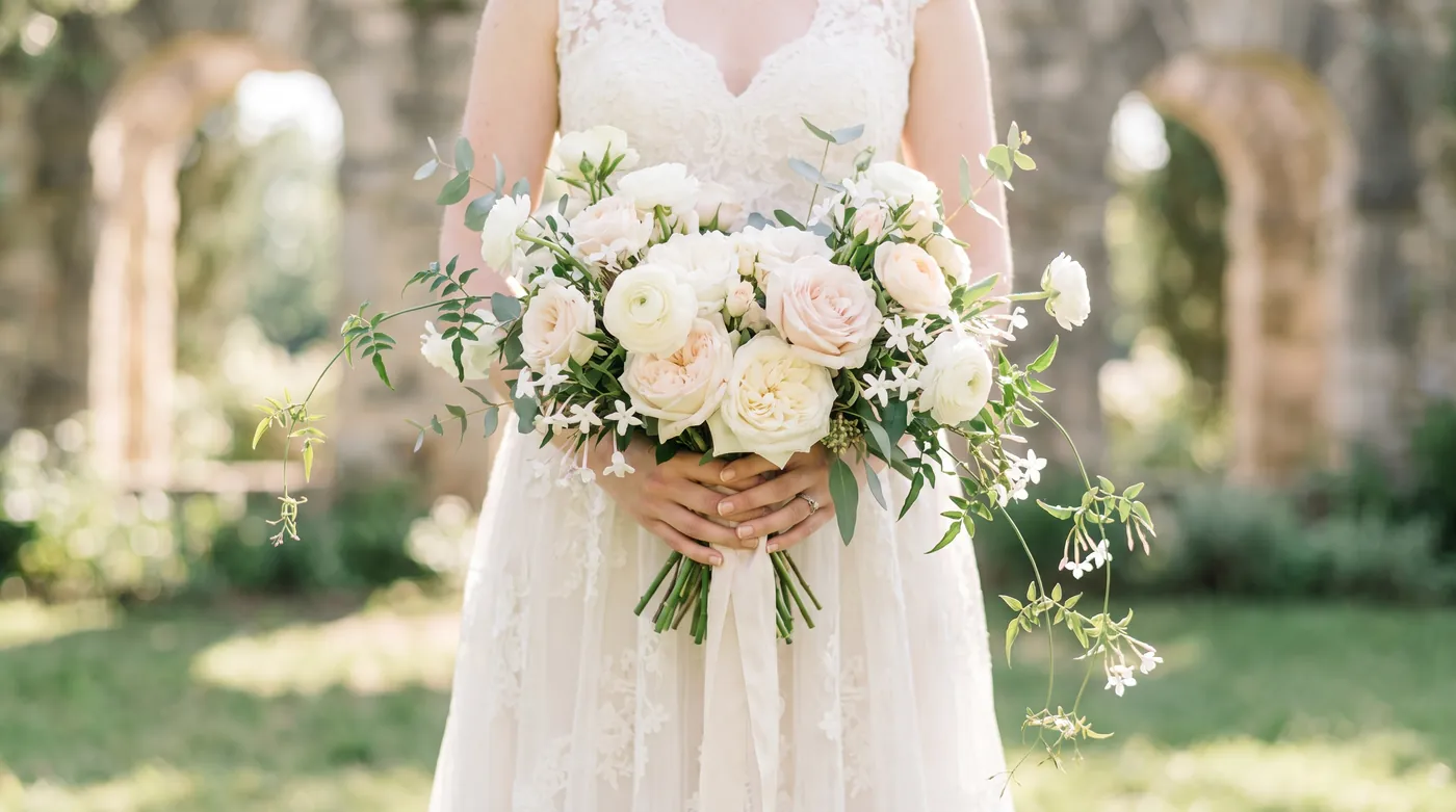 A bride holding a white and blush bridal bouquet